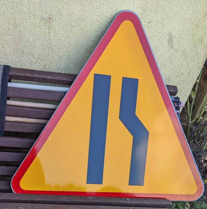 Znak drogowy,  prawostronne  zwężenie drogi, długość boku 90 cm