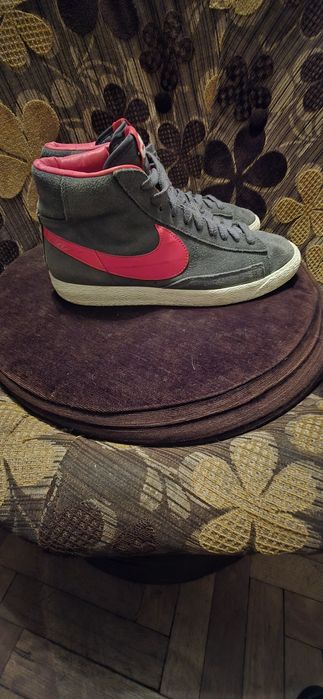 To są szare zamszowe buty Nike Blazer Mid z czerwonymi akcentami.