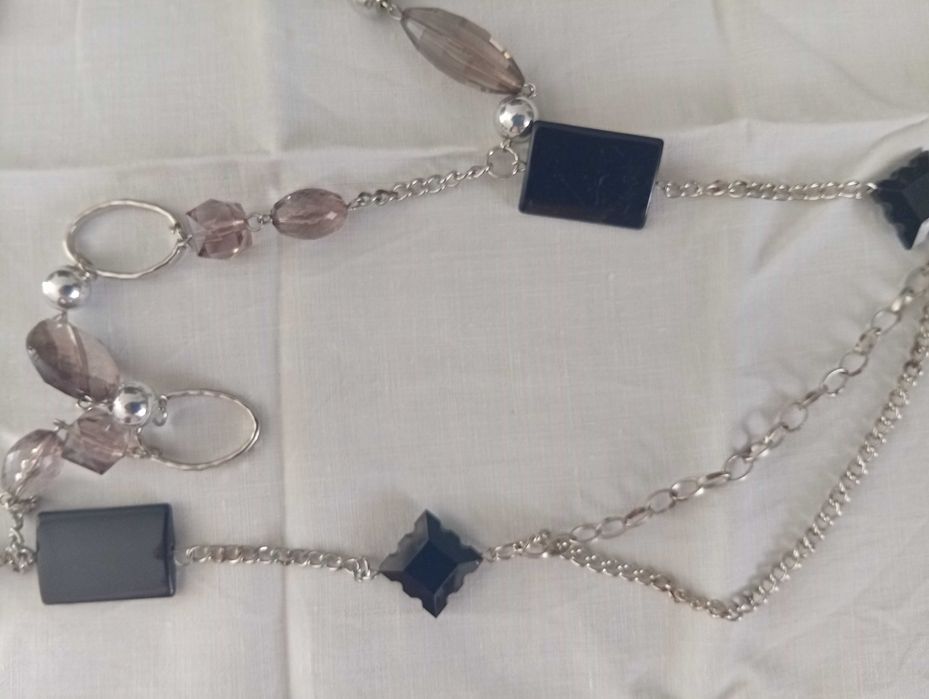 Colar em metal prateado, com aplicações pretas e cinza rosado