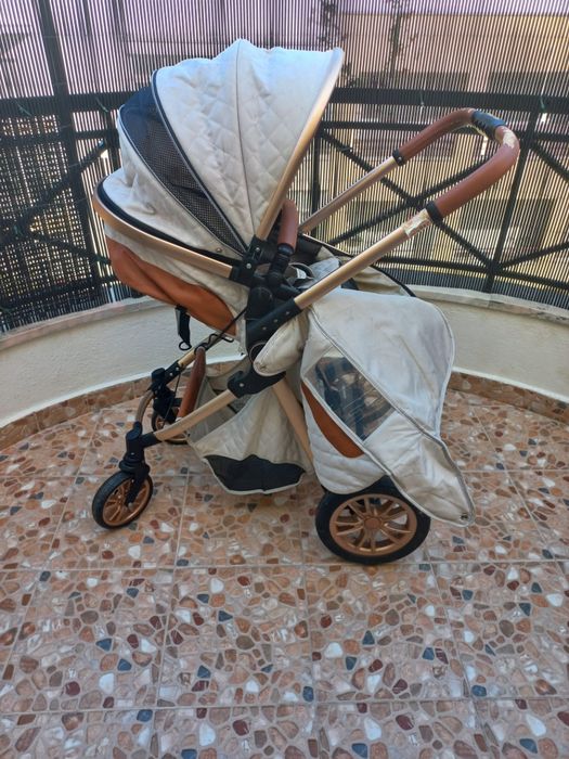 Carrinho de bebé com mmarcas de uso no puxador.