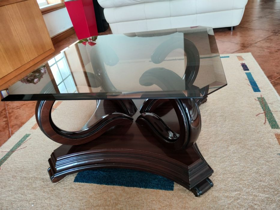 Mesa de centro centro com pés em madeira e tampo em vidro .