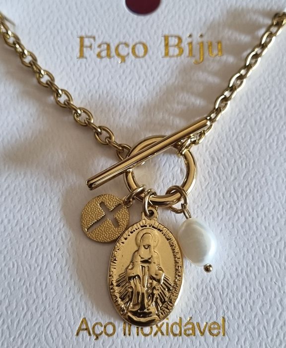 Colar dourado, em aço, com 3 pingentes diferentes. Fecho em T à frente