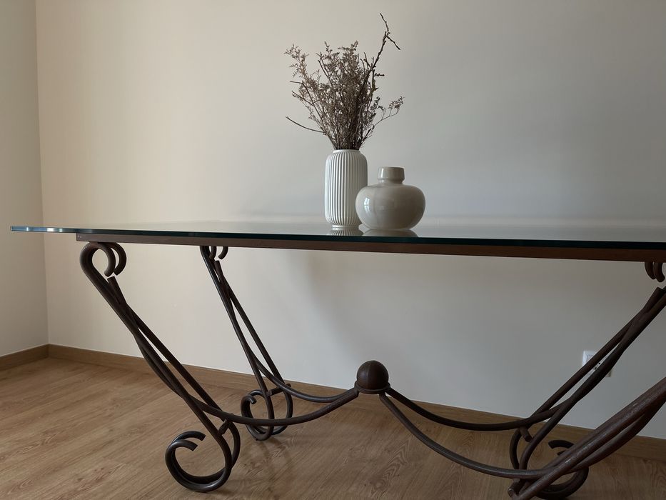 Mesa de jantar com tampo em vidro e base em ferro forjado