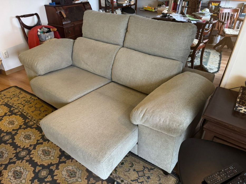 Sofá de 2 lugares com chaise long e arrumação nos braços.