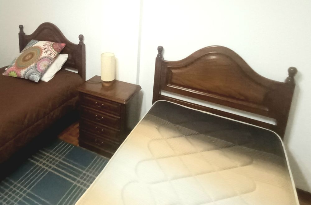 Duas camas de solteiro e mesa de cabeceira em madeira maciça