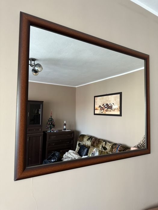 Lustro z brązową ramą.