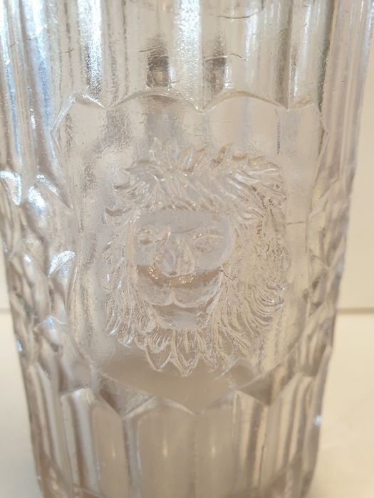 Antiga caneca de cerveja com cabeça de leão em vidro prensado