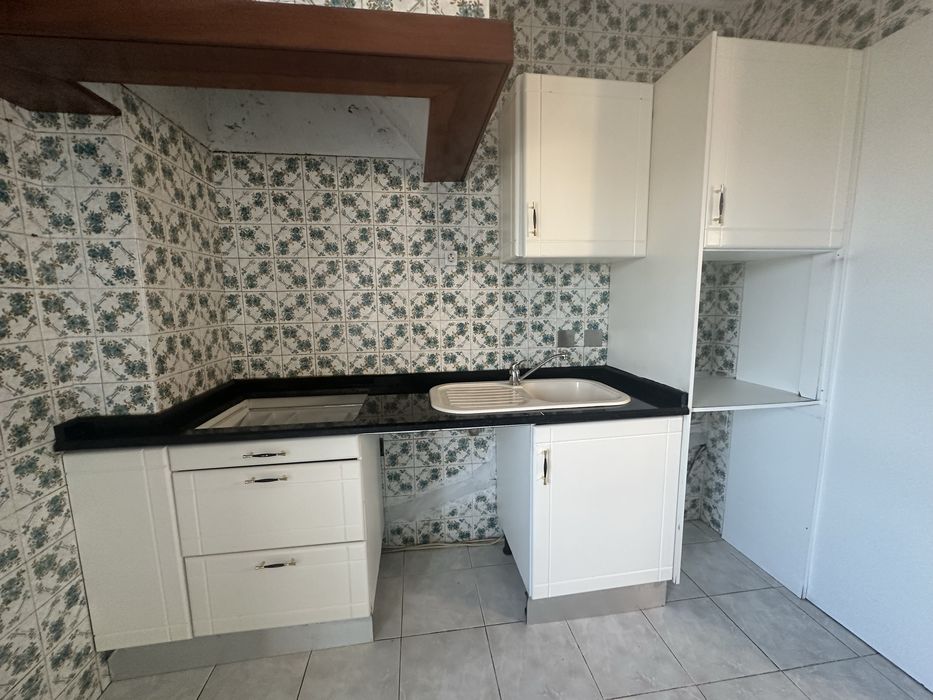 Móveis de cozinha brancos com balcão de granito