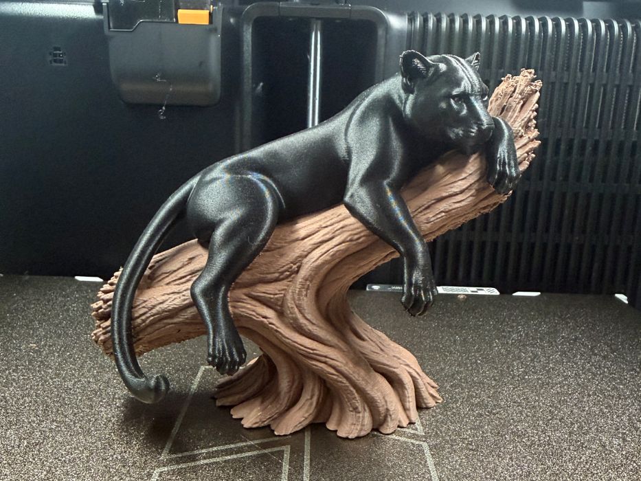 Escultura decorativa pantera negra deitada no tronco