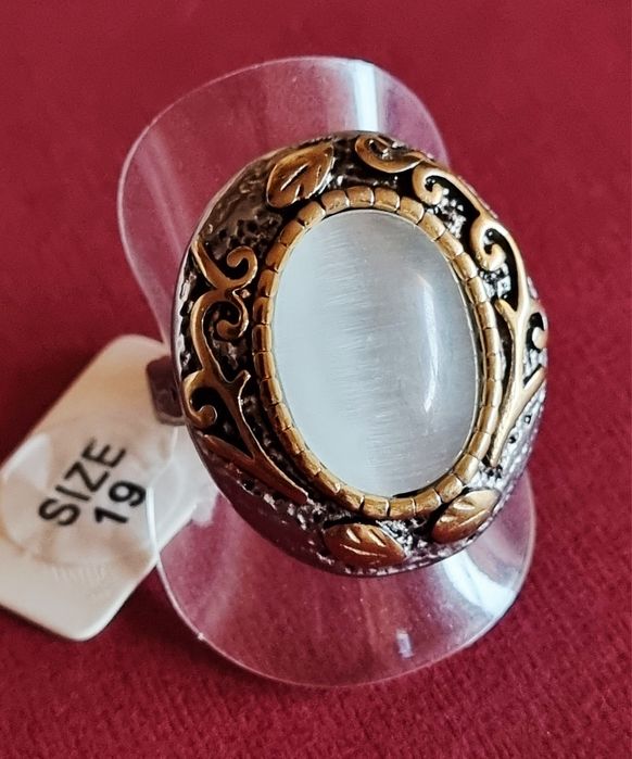 Anel bicolor, em aço, com grande pedra oval "olho de gato". T19/20