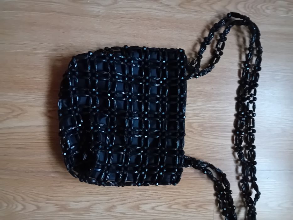 Torebka koloru czarnego z koralików na dłuszych paskach .
