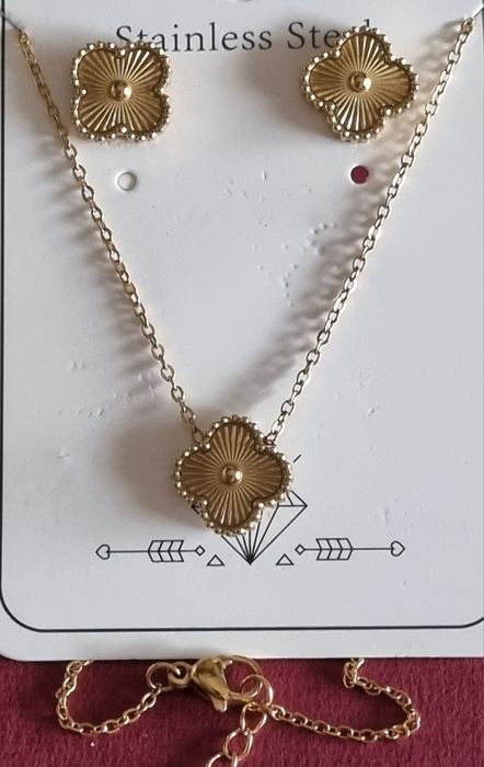 Conjunto dourado (colar e brincos), em aço, com trevo estriado.