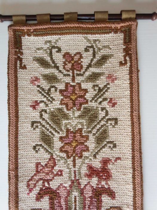 Pequeno painel em bordado de Arraiolos, com varão para pendurar, usado