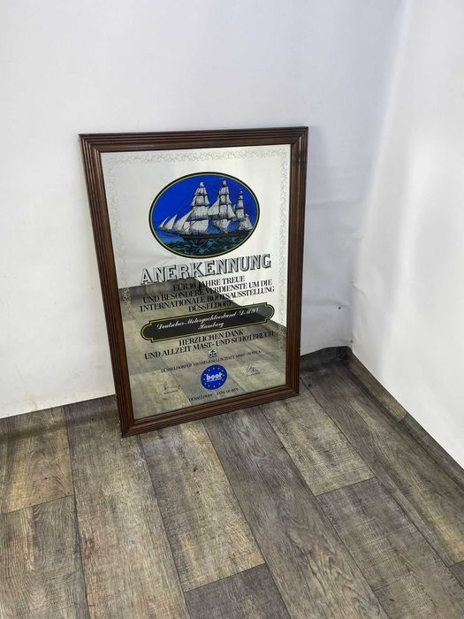 Lustro z reklamą w drewnianej ramie