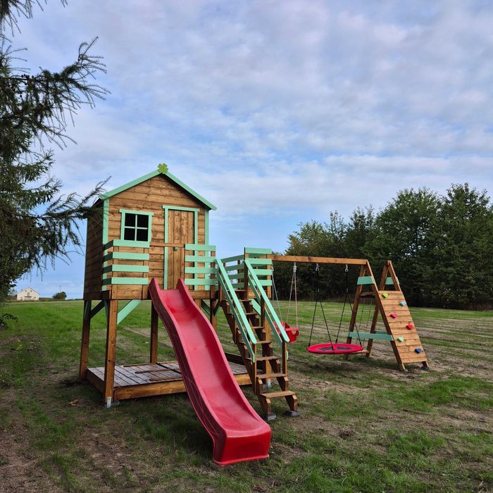 Plac zabaw Domek na powiększonym podeście z huśtawkami i ścianką wsp.