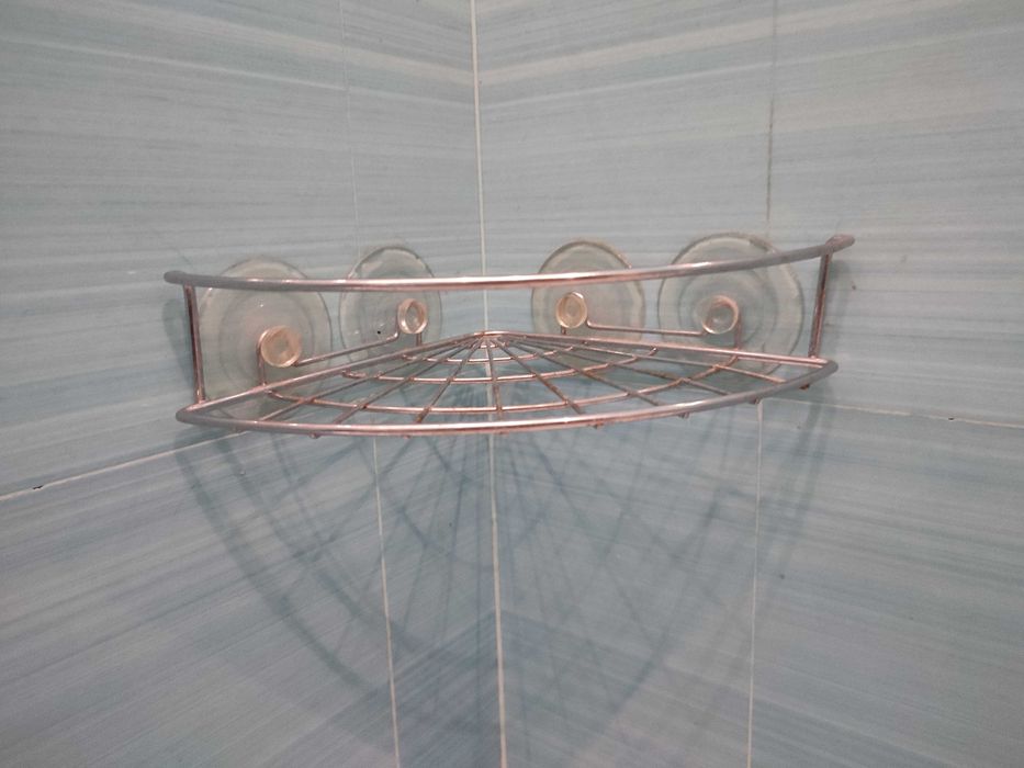 Угловая металлическая полка для ванной на присосках.