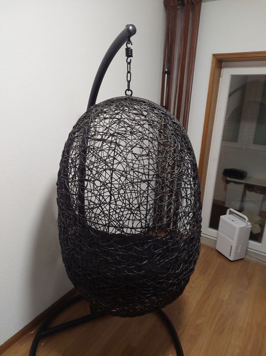 Cadeira suspensa de jardim com almofada.