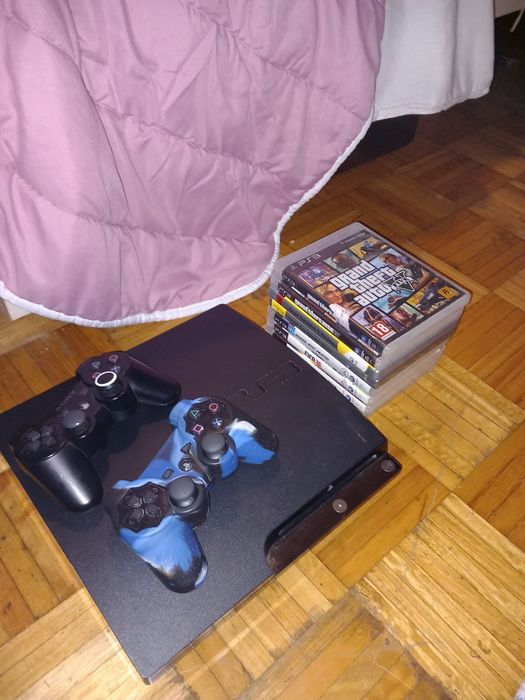 PS3 com dois comandos e jogos.