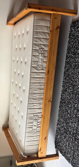 Cama em madeira maciça e colchão.