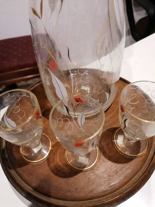 Garrafa de licor e três copos em vidro
