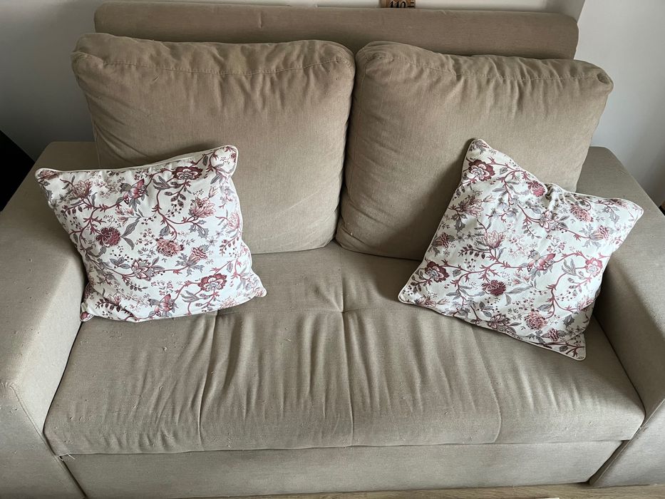 Sofá cama de dois lugares com marcas de uso