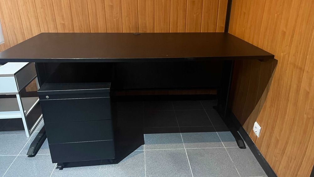 Secretária preta e modulo de gavetas.