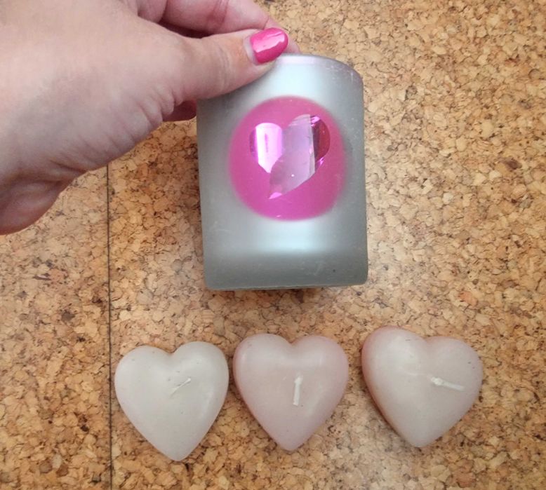 Copo em tons de rosa com três velas em formato de coração