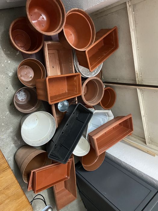 Conjunto composto por varios vasis e floreirasde plastico e a um vaso