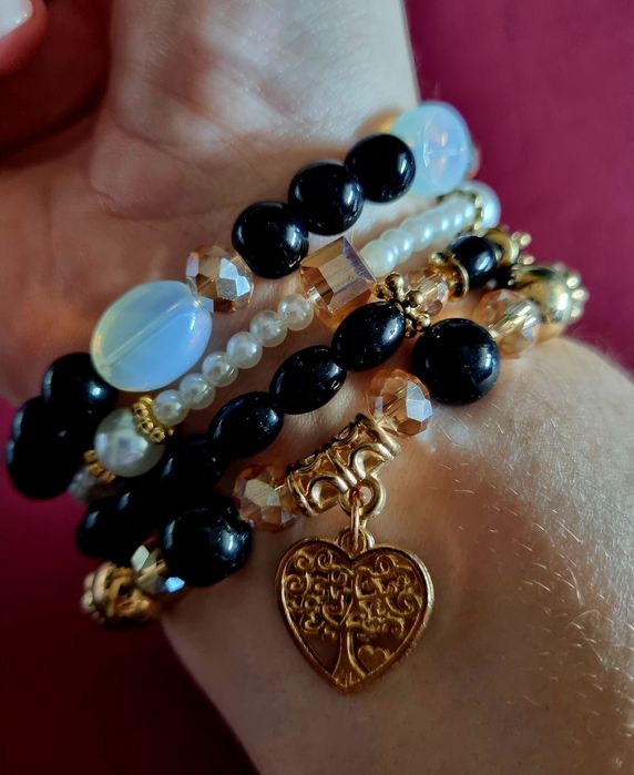 Conjunto de 4 pulseiras elásticas em tons de preto e dourado.