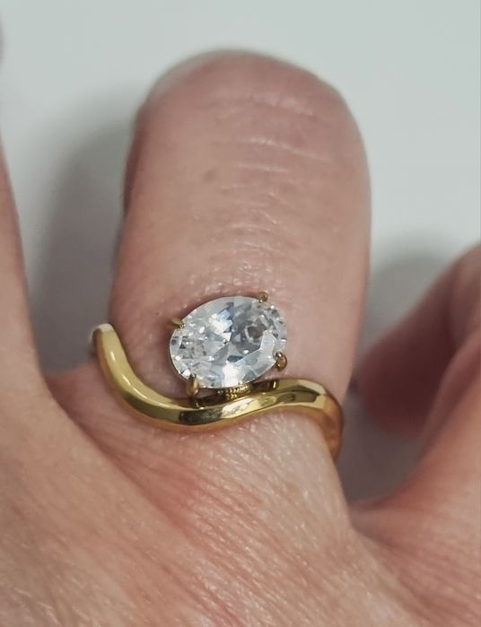Anel dourado, em aço, muito diferente e com um ponto de luz oval. Ajustável