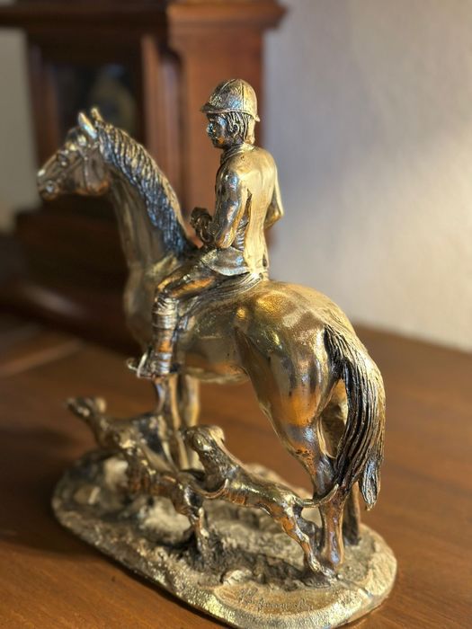 Estátua em metal de cavaleiro com cães