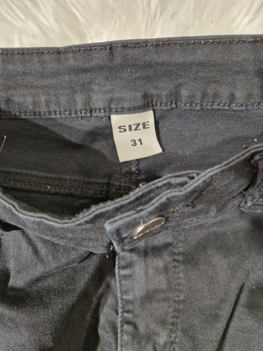 Jeansy damskie czarne poszarpane nogawki, zameczki