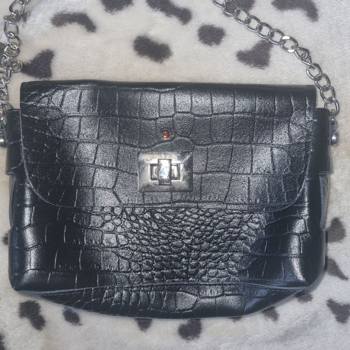 Mała czarna torebka na srebrnym łańcuszku.