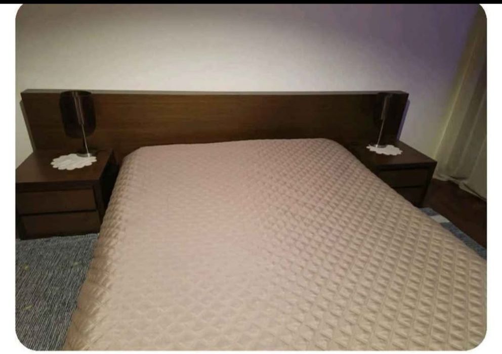 Cama de casal com mesinhas de cabeceira.