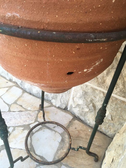 Pote em terracota com base em ferro batido