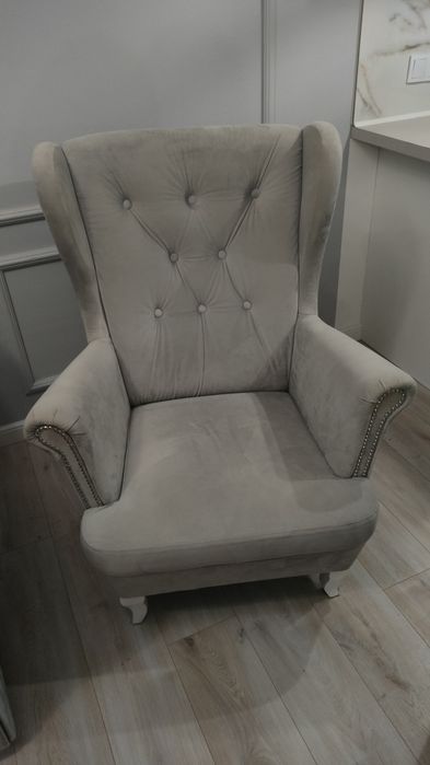 Szary fotel z białymi nogami