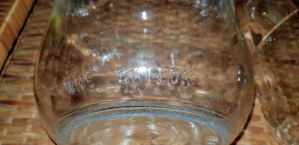 Garrafões de vidro com pega "ONE GALLON" e "ONE HALF GALLON"