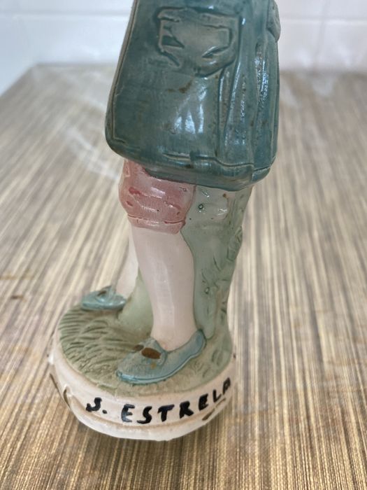 Estátua em cerâmica de um homem que segura um violino