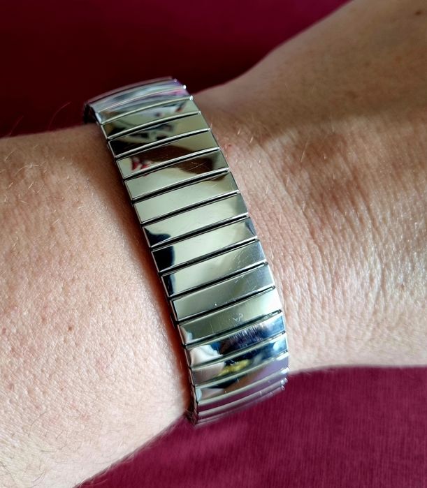 Pulseira elástica prateada, em aço inoxidável.