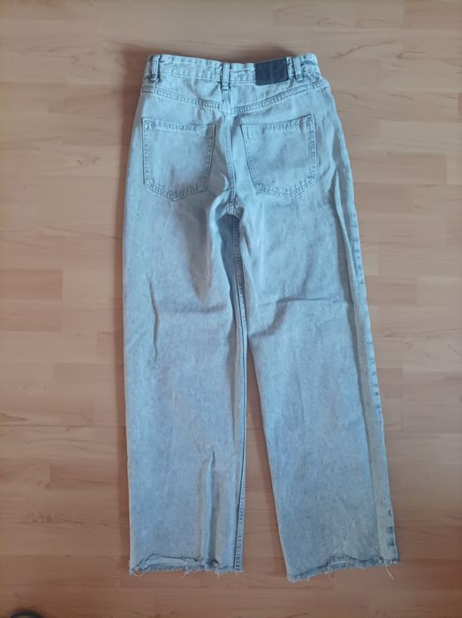 Spodnie jeansowe, poszarpana nogawka