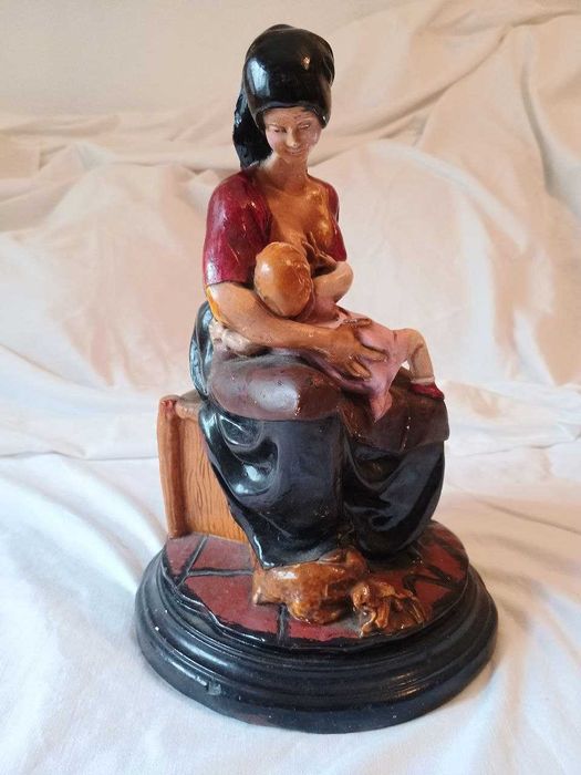Estatueta de mãe a amamentar bebé