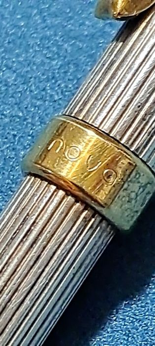 Caneta em prata contrastada.