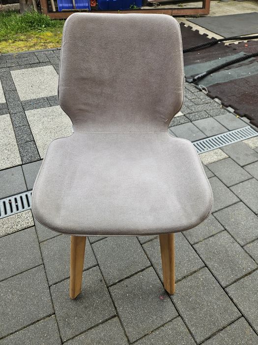 Popielate krzesło drewniane obite materiałem