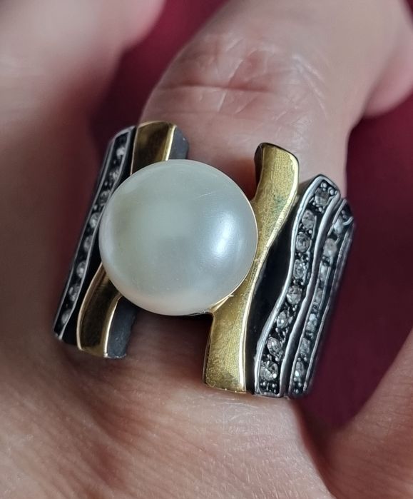 Anel bicolor, em aço, com zirconias e uma pérola no centro. T18