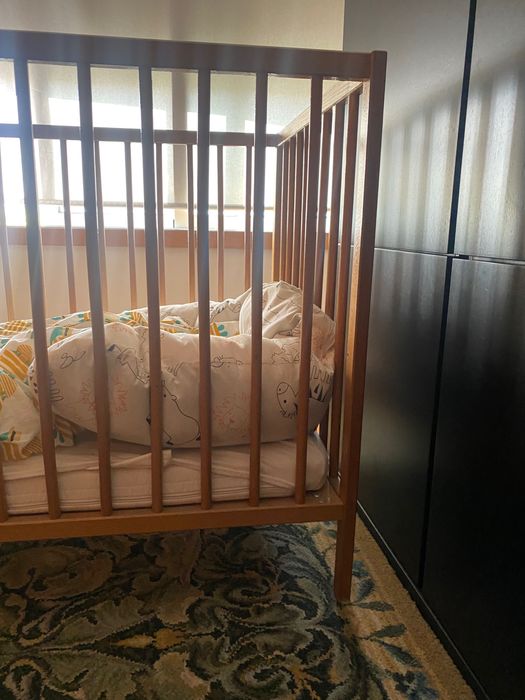 Cama de grades em madeira natural com colchão e resguardo