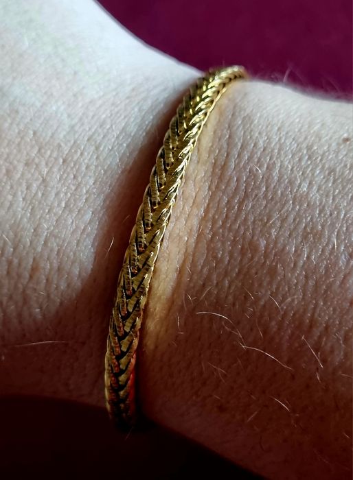 Pulseira dourada, em aço inoxidável. Tem extensor