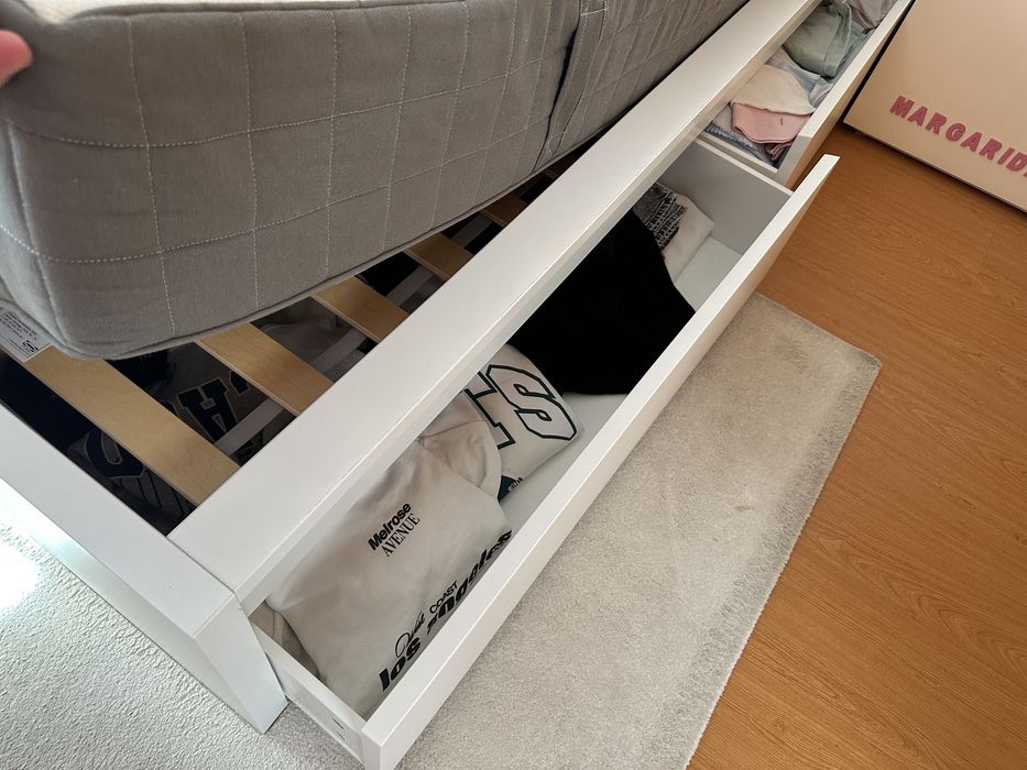 Cama de casal branca com colchão, com dimensões de 1,60 x 2 m. O