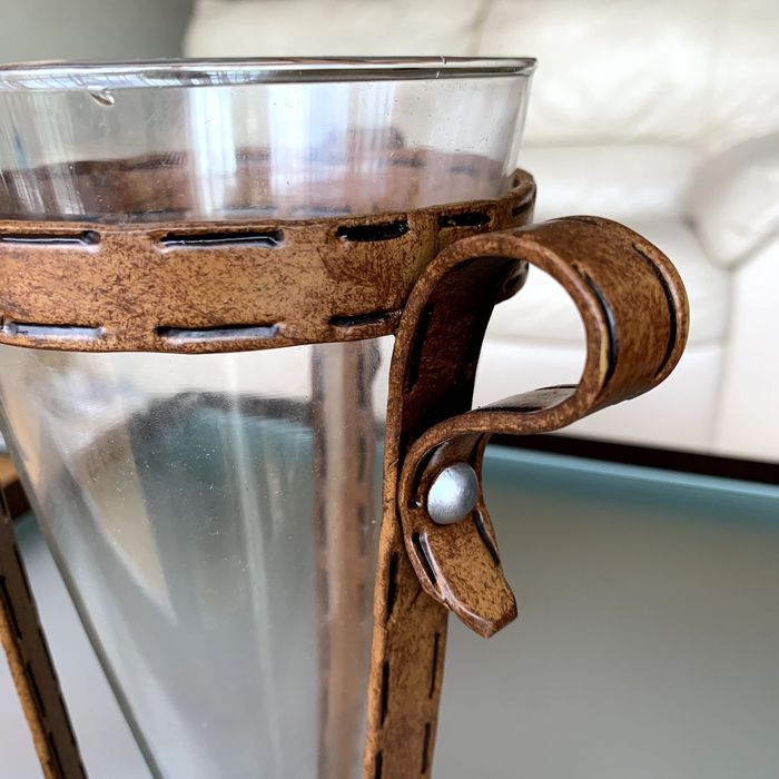 Vaso decorativo de vidro, cónico, com suporte rústico.
