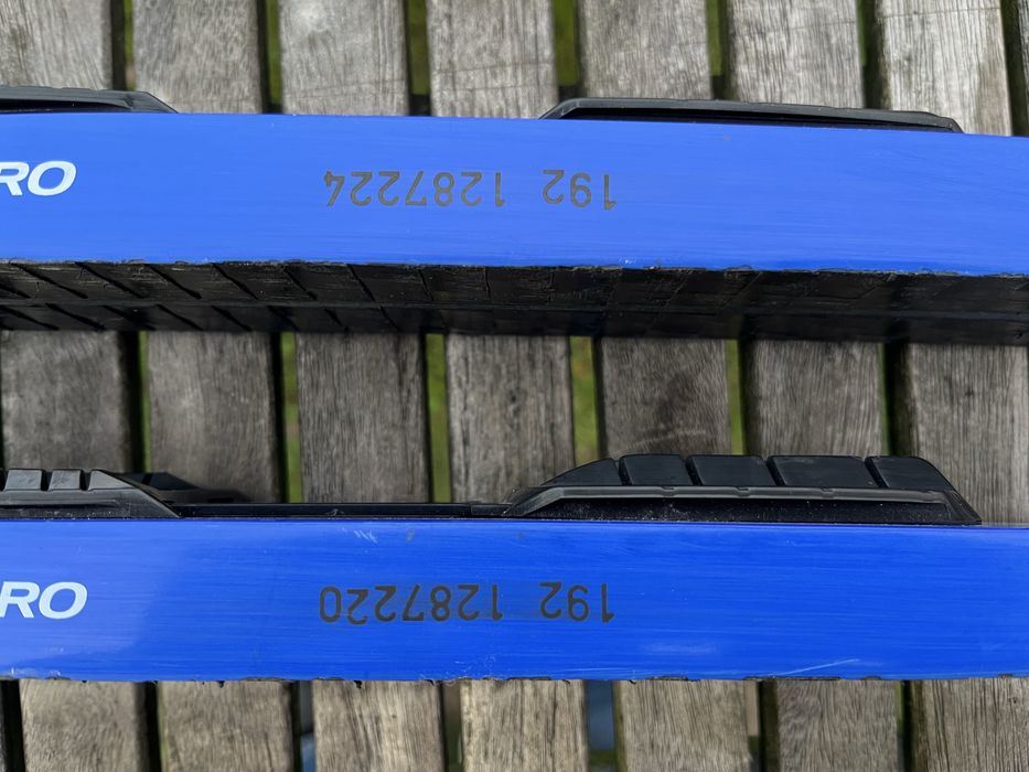 Zestaw narty biegowe, kijki, buty i pokrowiec.