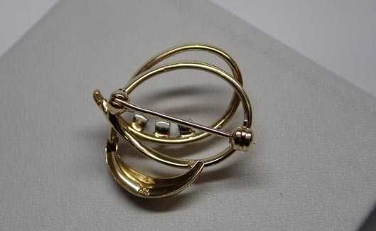 Złota broszka z diamentami pleciona ozdoba.